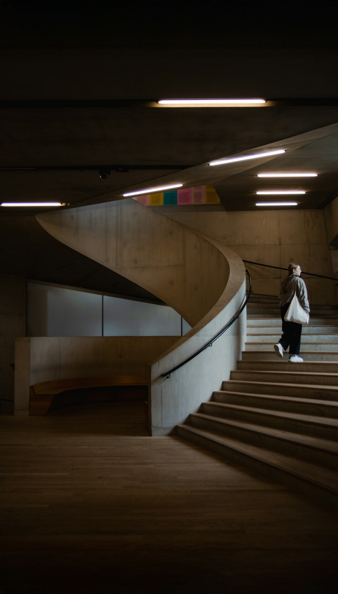 Elegant woman in refined evening attire standing in a minimalist architectural space